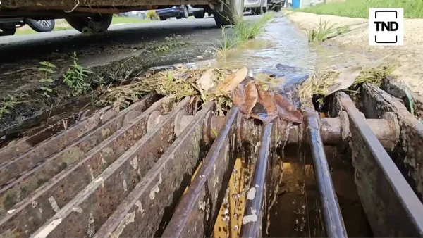 Agua de un salidero corriendo por la calle hacia una alcantarilla en una urbanización de Toa Alta